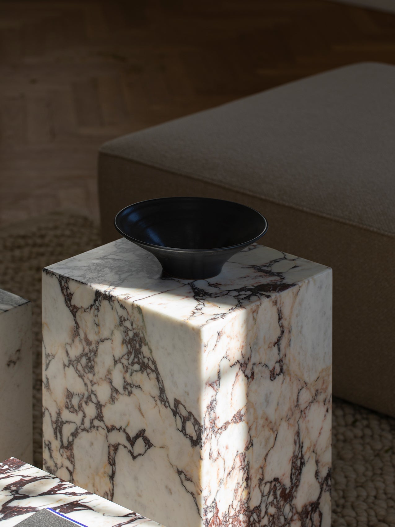 Table d'appoint minimaliste en marbre et pierre avec piédestal haut et forme sculpturale pour salon et couloir