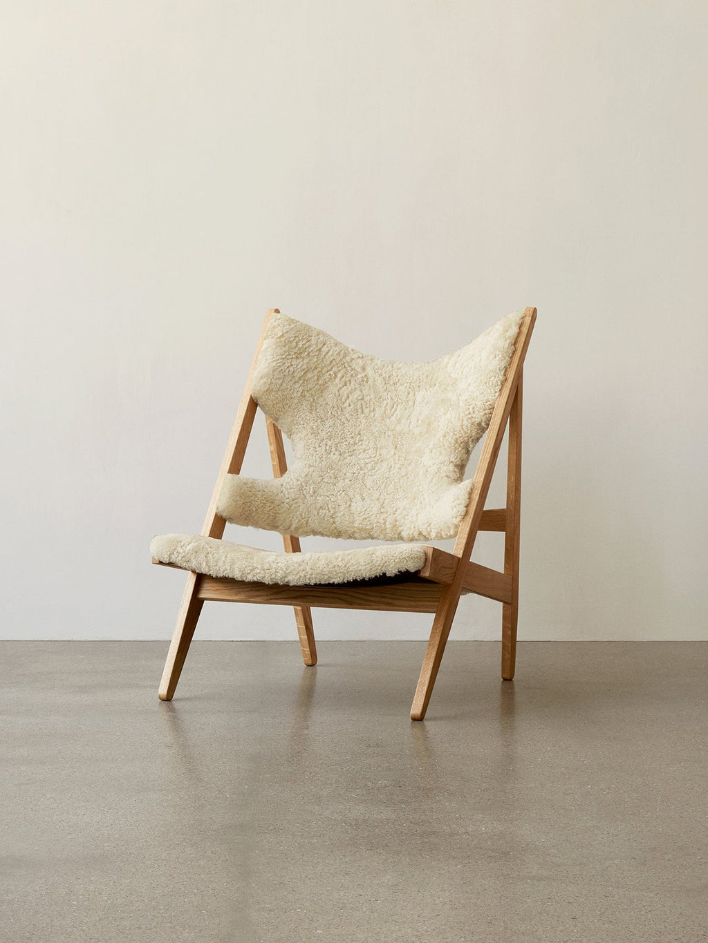 Fauteuil de salon et de chambre en peau de mouton et chêne avec découpe au niveau des accoudoirs