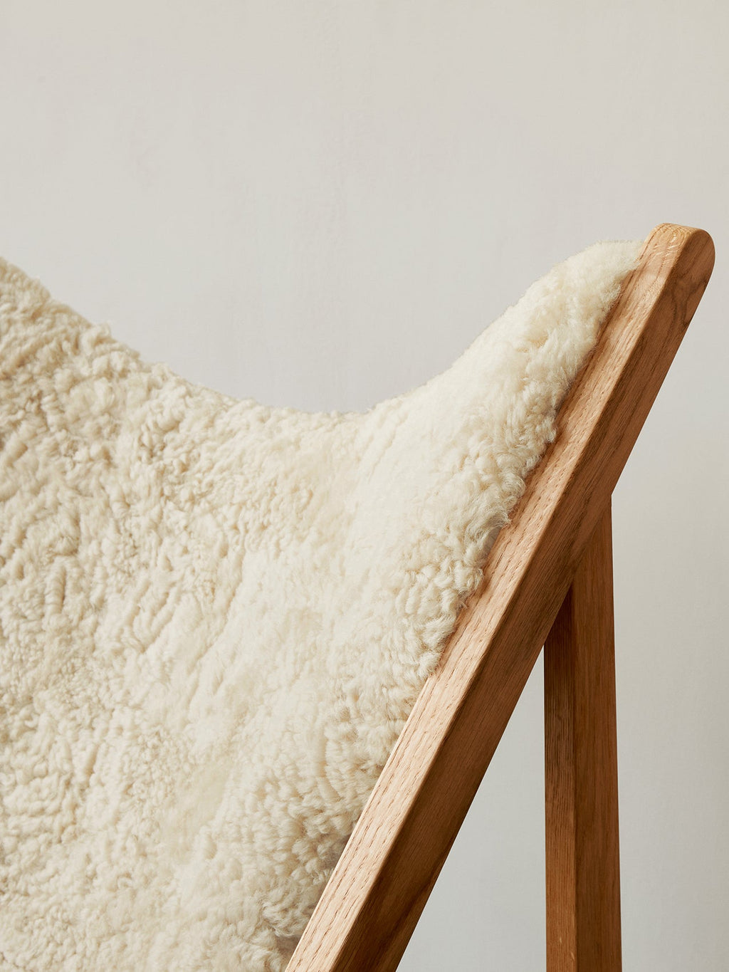Fauteuil de salon et de chambre en peau de mouton et chêne avec découpe au niveau des accoudoirs