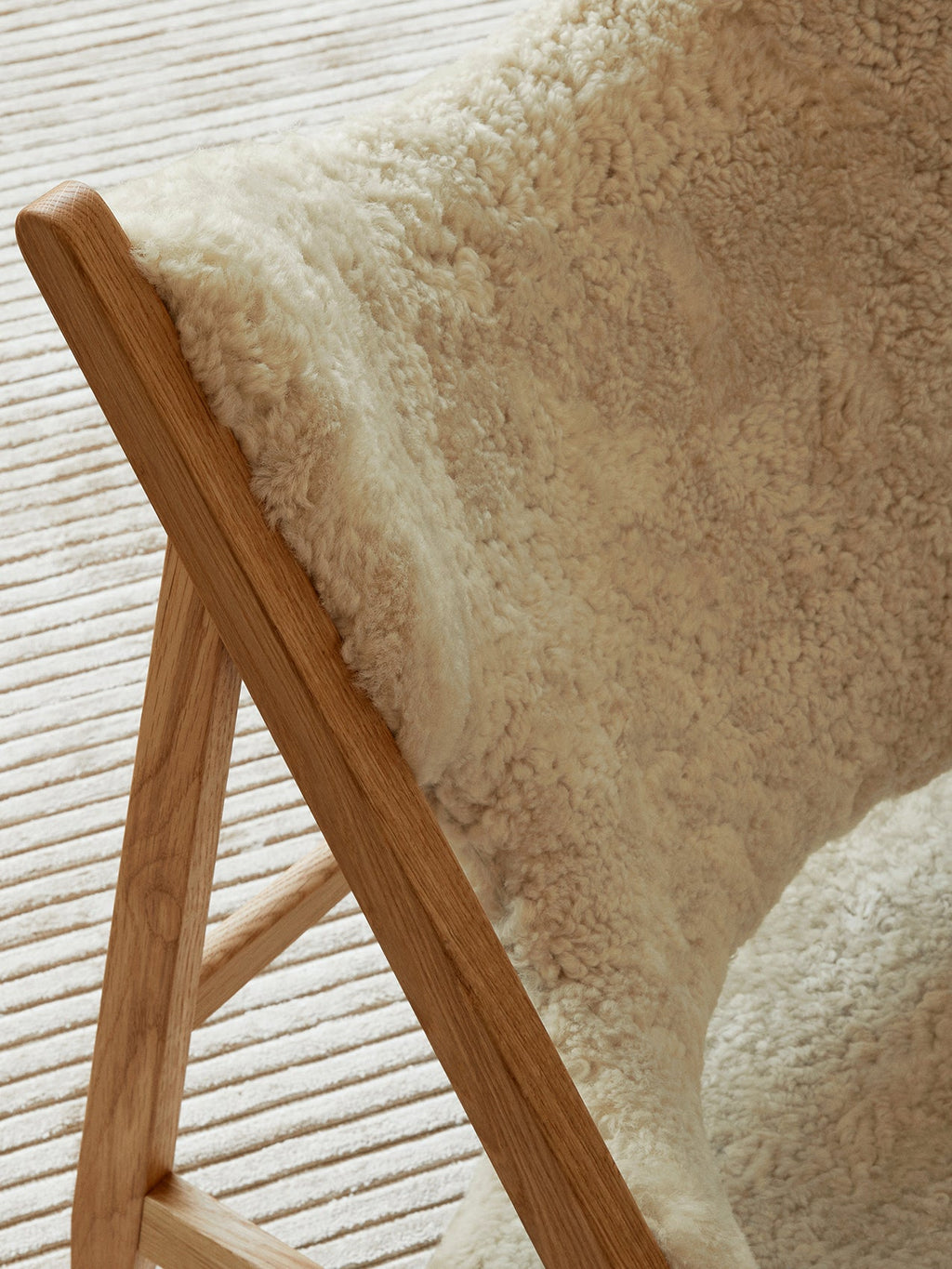 Fauteuil de salon et de chambre en peau de mouton et chêne avec découpe au niveau des accoudoirs