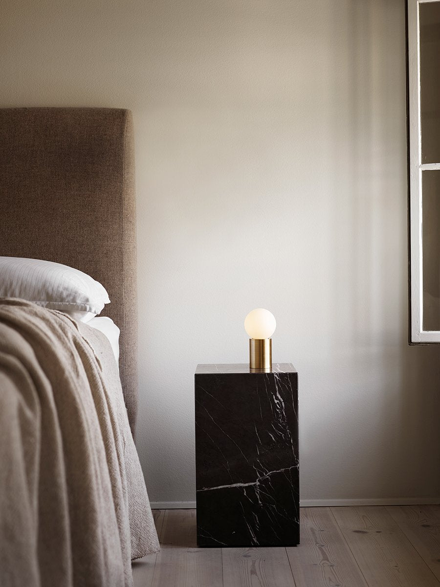Table d'appoint minimaliste en marbre et pierre avec piédestal haut et forme sculpturale pour salon et couloir